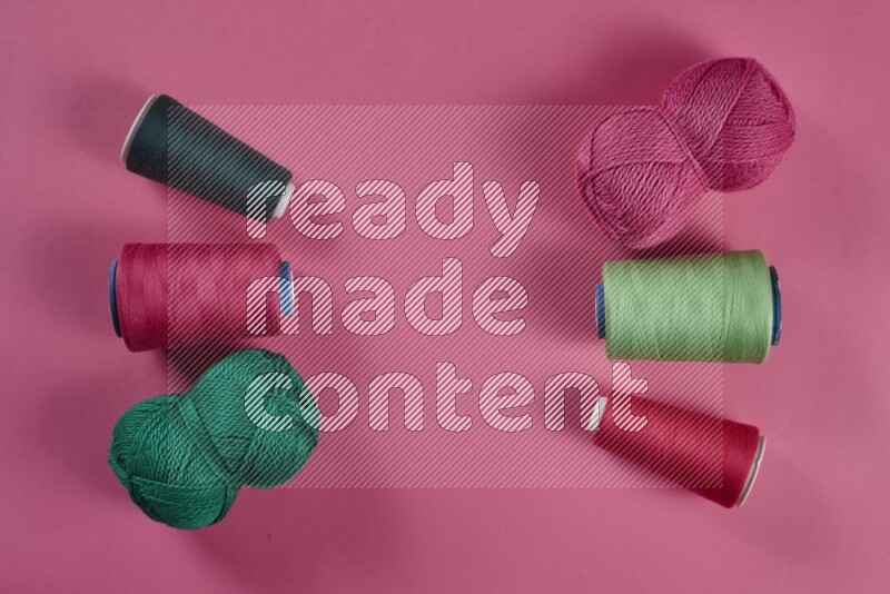 مجموعة من أدوات الخياطة والتفصيل خضراء وزهرية اللون على خلفية زهرية