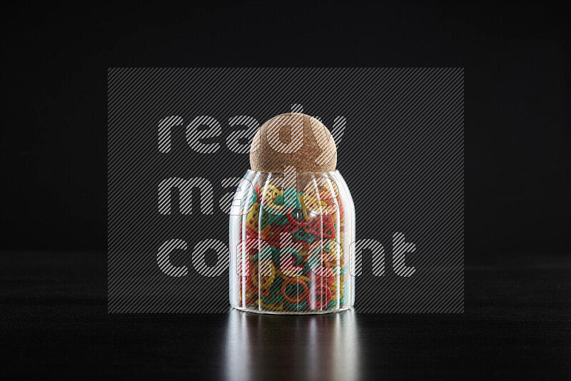 Snacks in a glass jar on black background