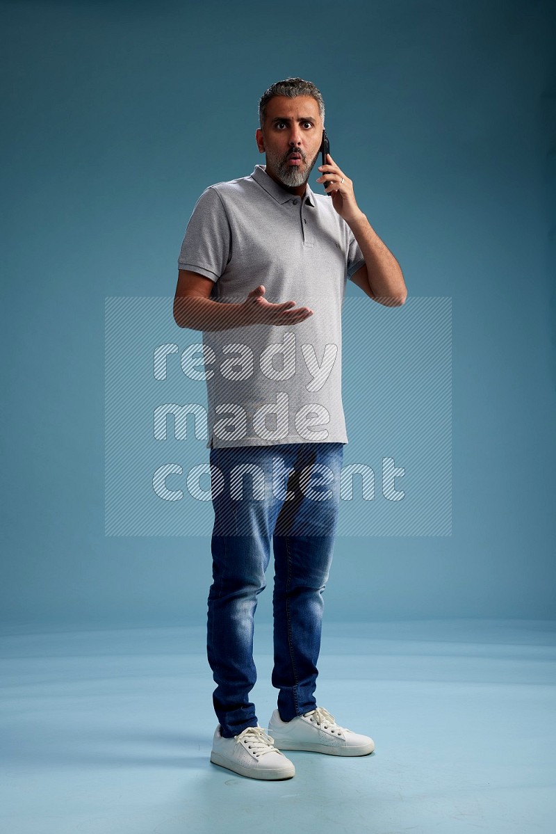 Man Standing talking on phone on blue background