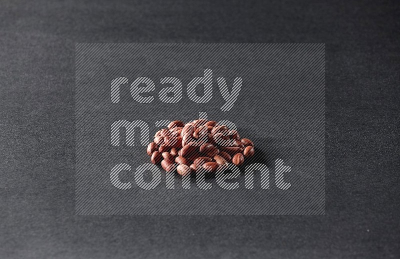 A bunch of red skin peanuts on a black background in different angles