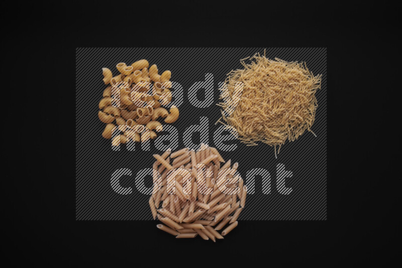 Different pasta types in bunches on black background