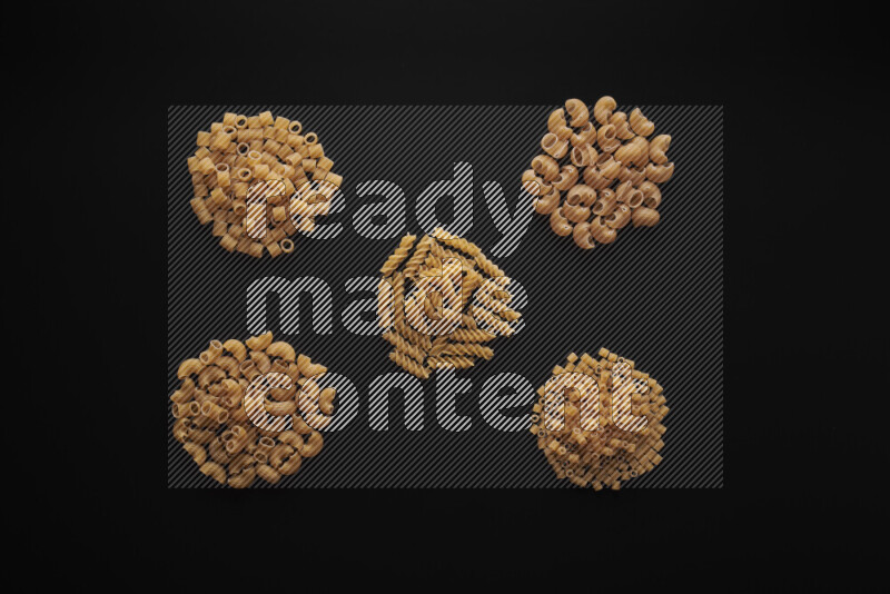 Different pasta types in bunches on black background