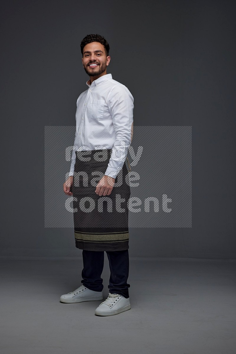 A man wearing smart casual and apron standing and making multi poses eye level on a gray background