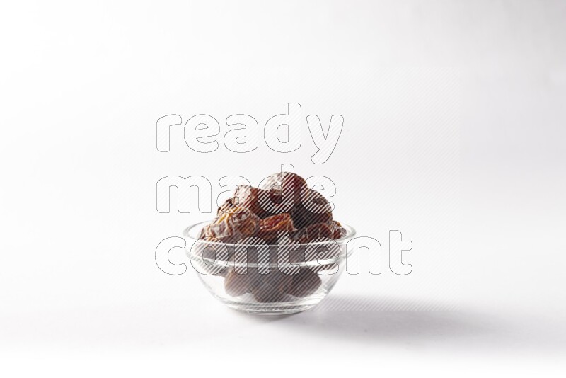 Dates in a glass bowl on white background