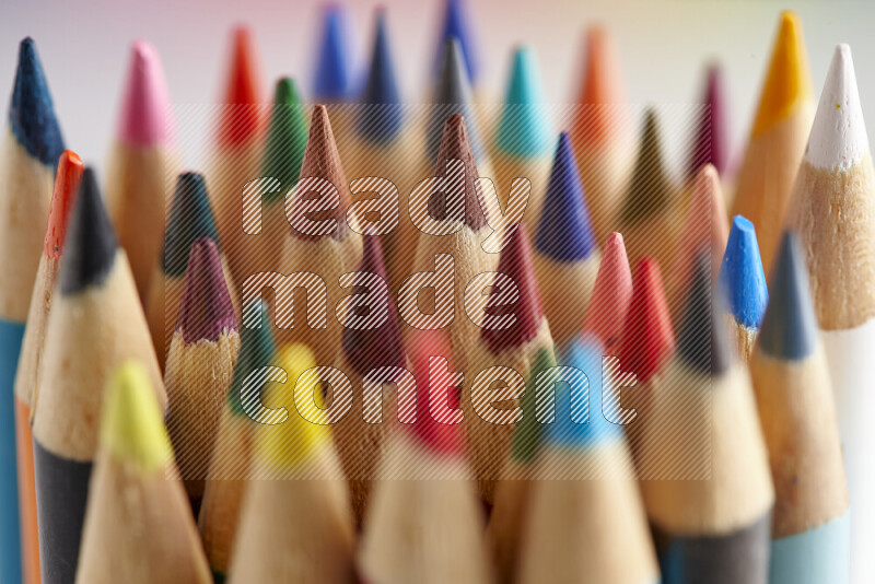 The image captures a close-up of sharpened colored pencils on multicolored background
