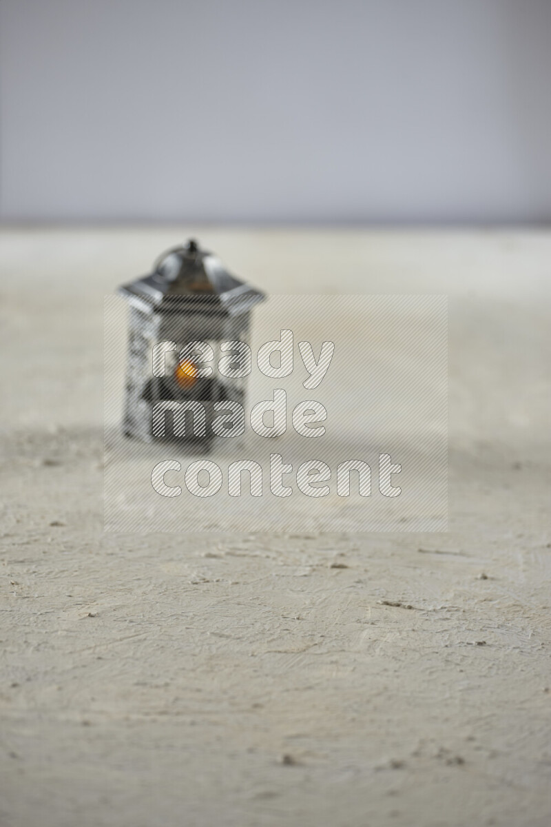 A lantern placed on a textured white background