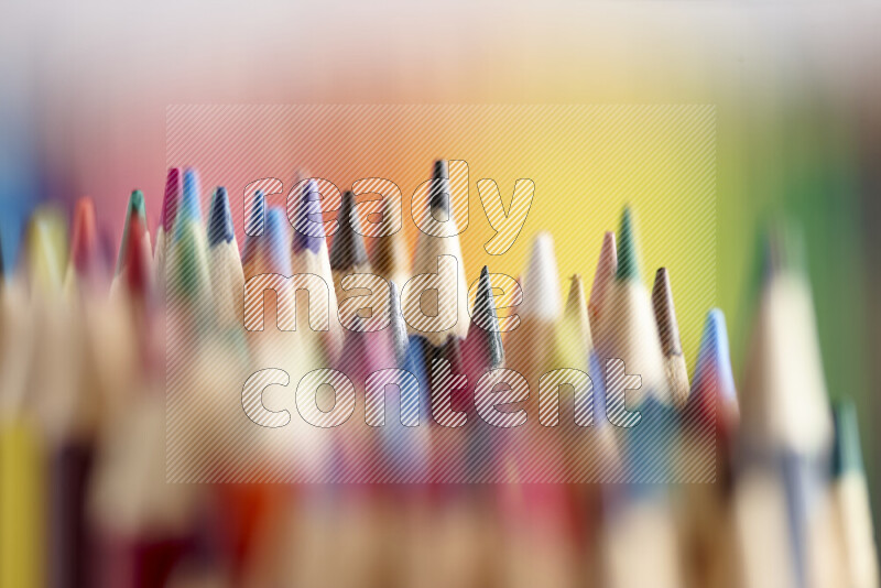The image captures a close-up of sharpened colored pencils on multicolored background