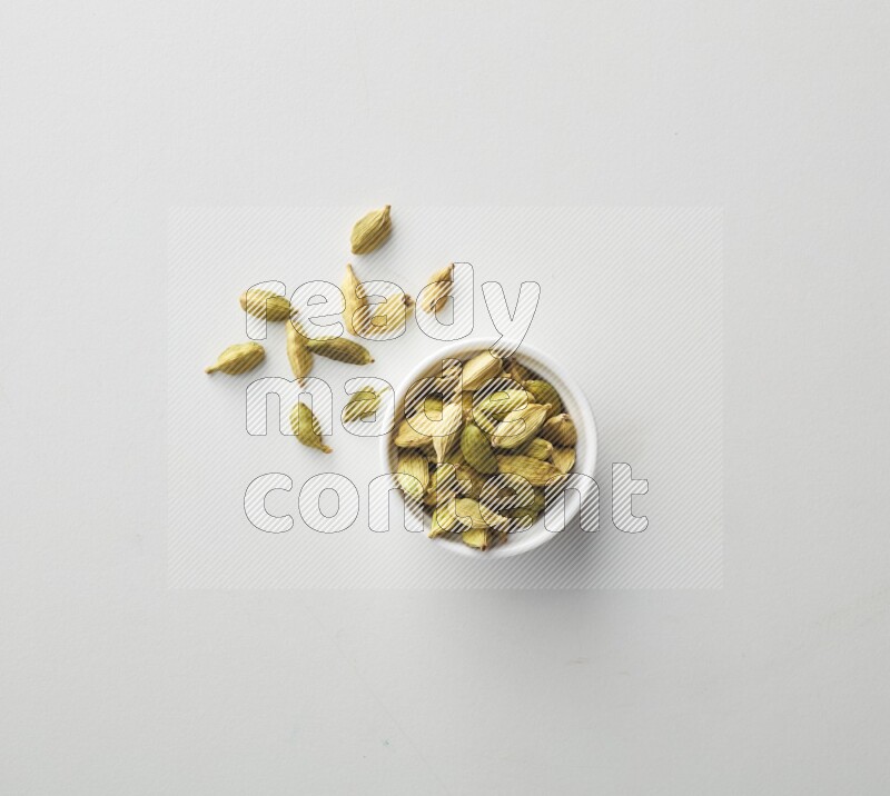 Top-view shot of Cardamon in a container on white background