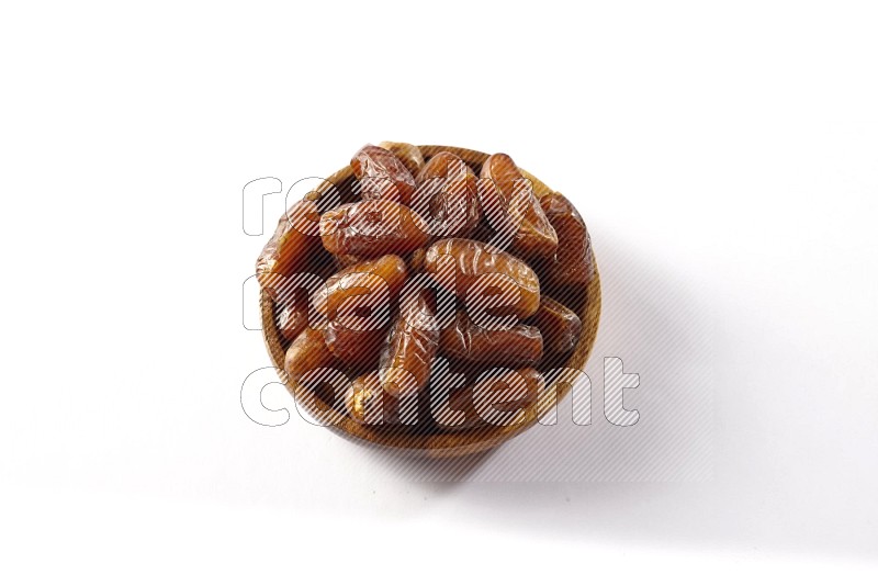 Dates in a wooden bowl on white background