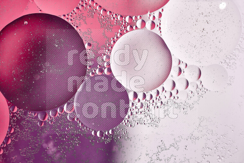 Close-ups of abstract oil bubbles on water surface in shades of white, purple and pink