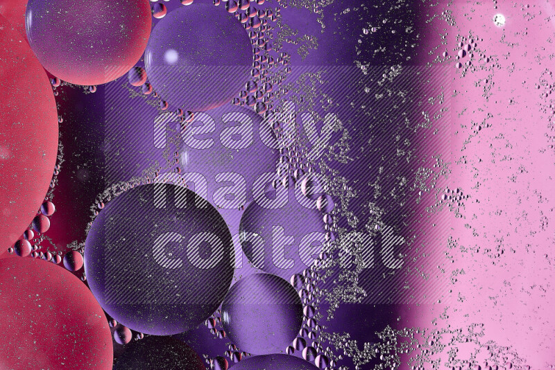 Close-ups of abstract oil bubbles on water surface in shades of red, purple and pink