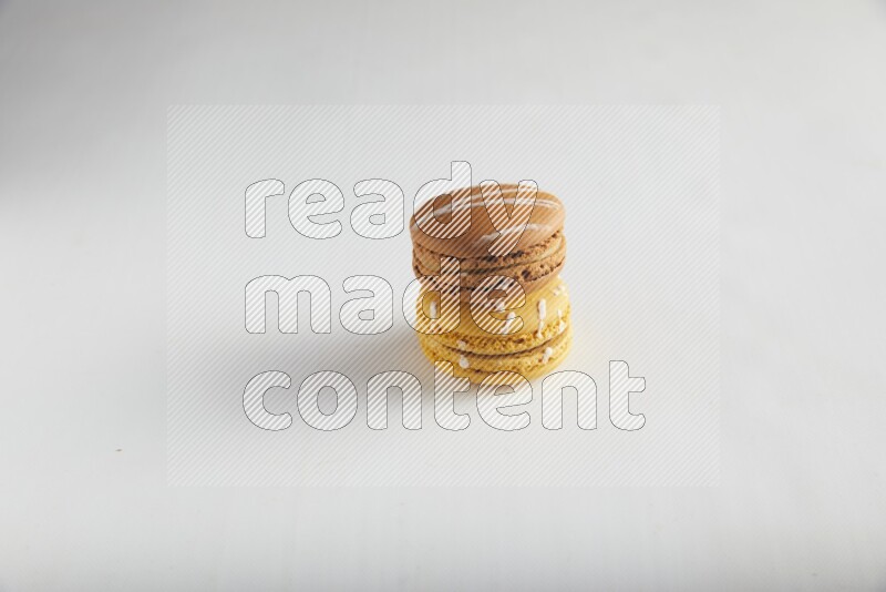 45º Shot of of two assorted Brown Irish Cream, and Yellow Piña Colada macarons on white background