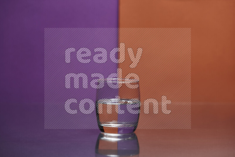 The image features a clear glassware filled with water, set against purple and dark orange background