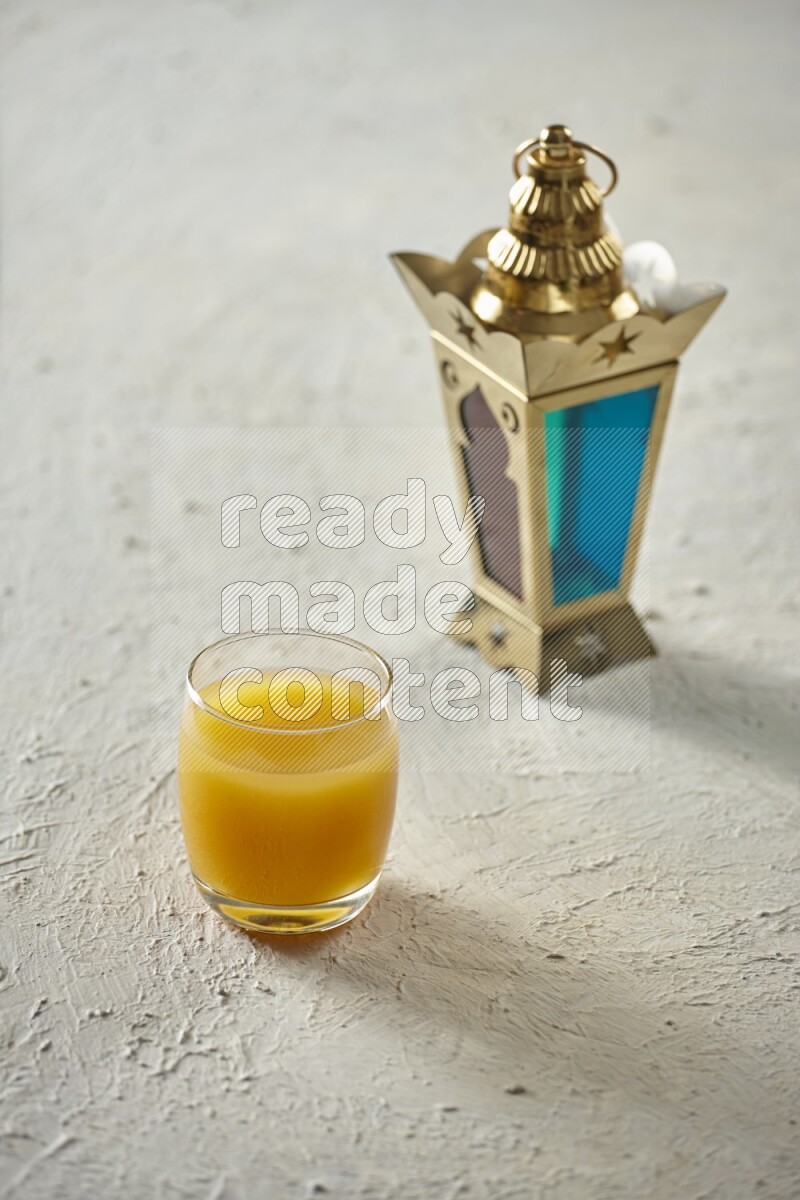 A golden lantern with different drinks, dates, nuts, prayer beads and quran on textured white background