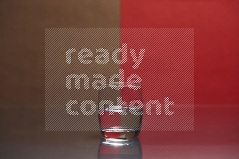 The image features a clear glassware filled with water, set against brown and red background