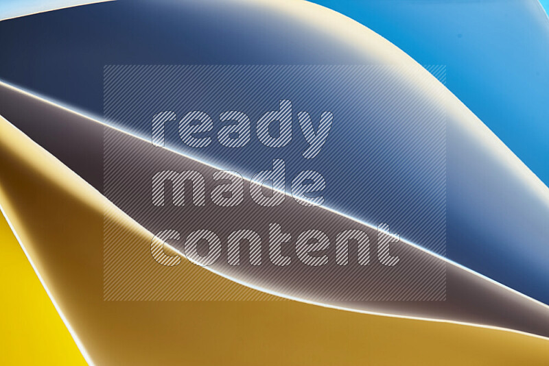 This image showcases an abstract paper art composition with paper curves in blue and yellow gradients created by colored light