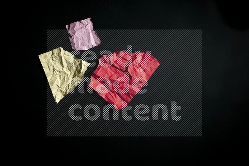 Crumpled multicolored paper on black background