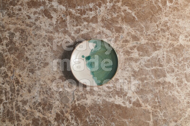 A decorative pottery plate on beige marble background