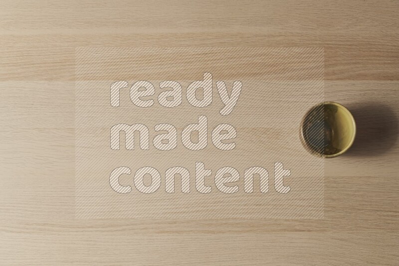 A multicolored pottery cup on light wooden background