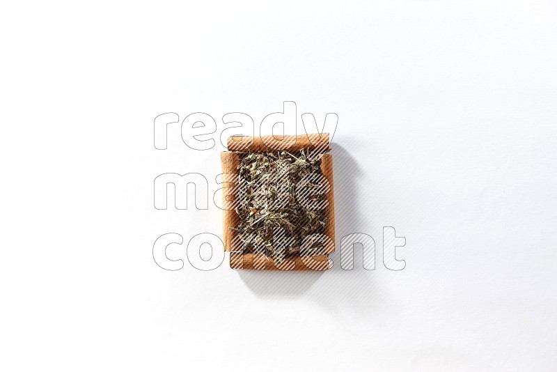 A single square of cinnamon sticks full of dried basil on white flooring