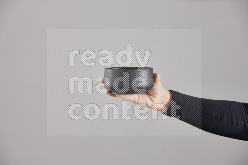 امرأة ترتدي عباءة سوداء تحمل أدوات فخارية مختلفة في أوضاع متعددة