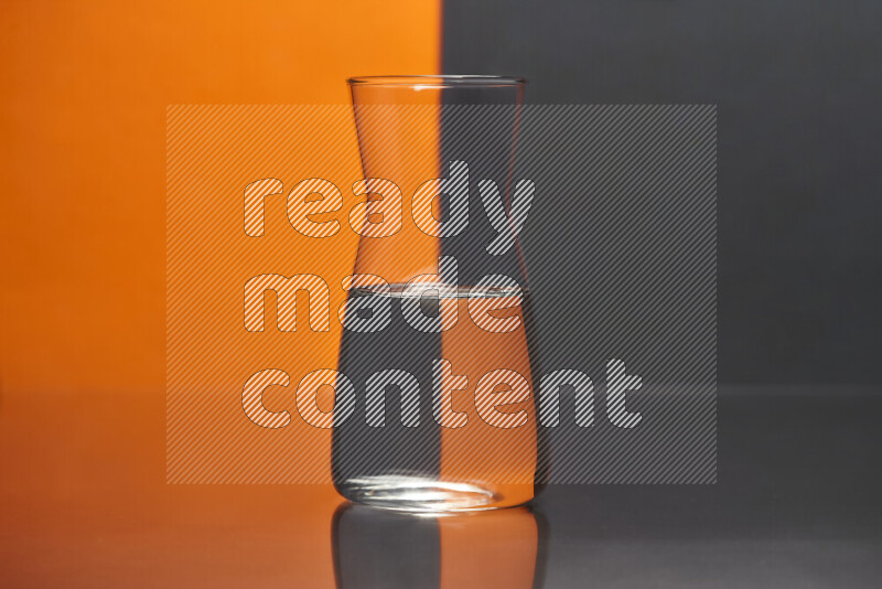 The image features a clear glassware filled with water, set against orange and black background