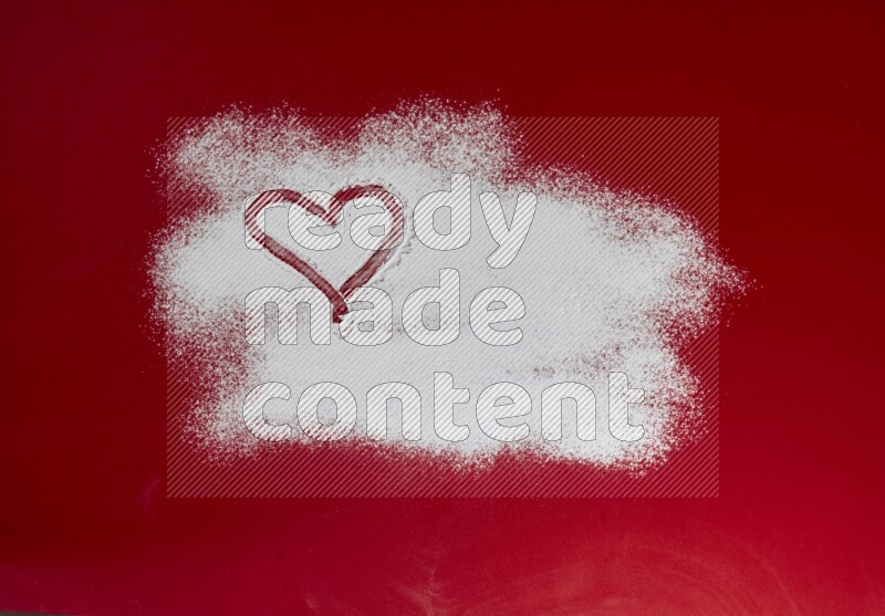 A heart drawn with powder on red background