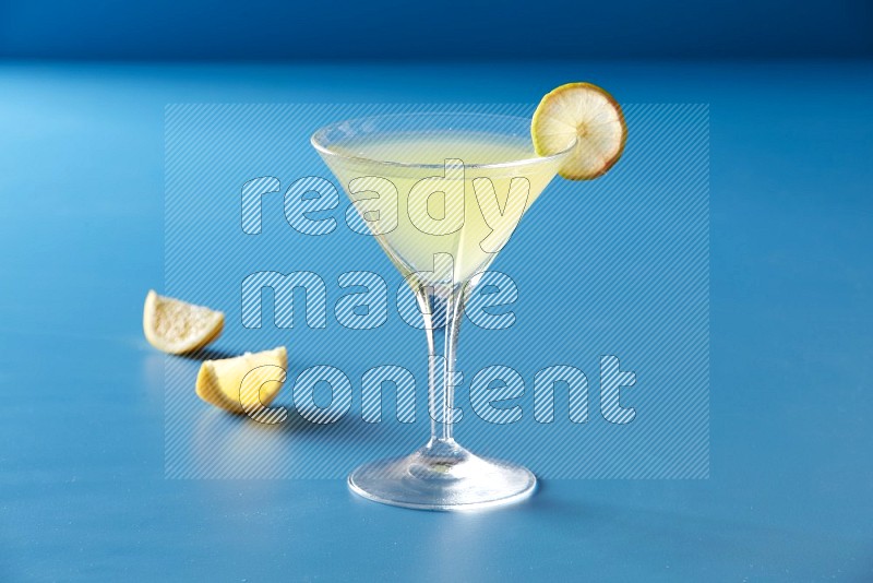 glass of lemon juice with lemon slice  on blue background