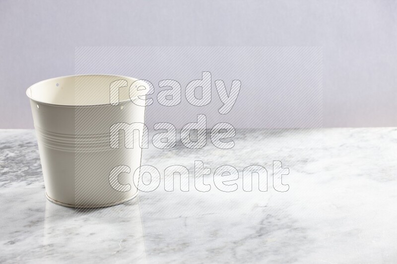 An empty white plant pot on grey marble background