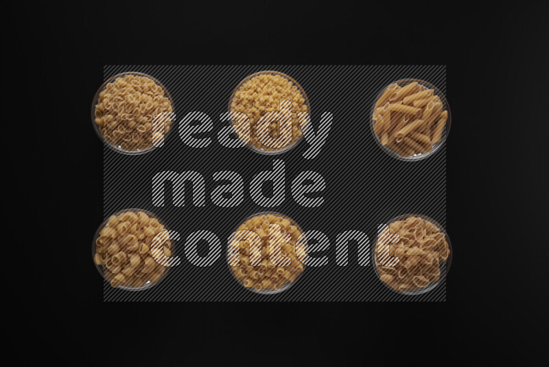 أنواع مختلفة من المعكرونة في أوعية زجاجية علي خلفية سوداء