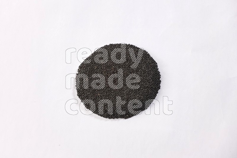 Black seeds in a circle shape on a white flooring in different angles