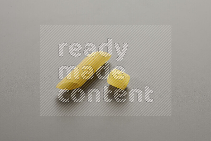 Penne pasta with other types of pasta on grey background