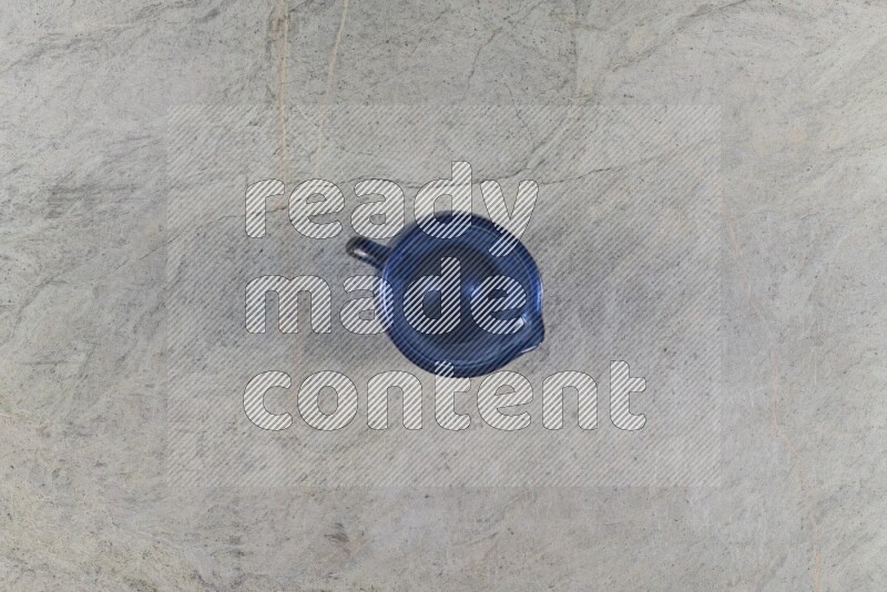 A colored glass jug on grey marble background