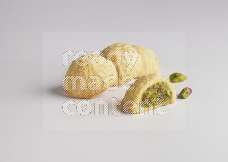 Four Pieces of Maamoul filled with pistachio  paste one of them is cut direct on white background