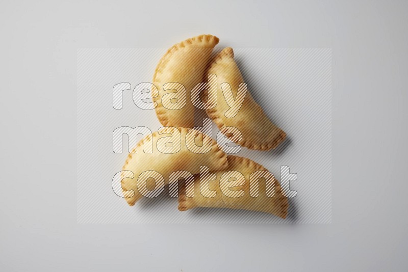 Four fried sambosa from a top angle on a white background