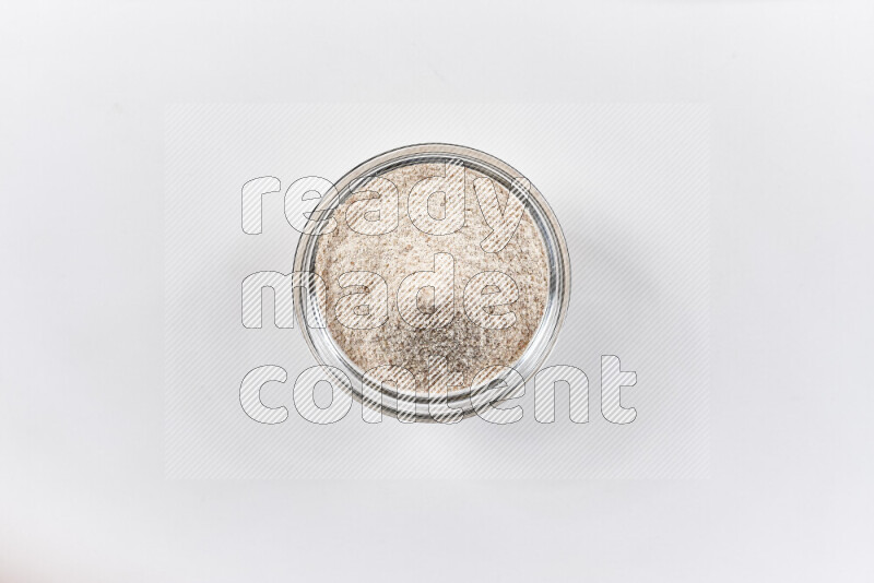 A glass bowl full of onion powder on white background