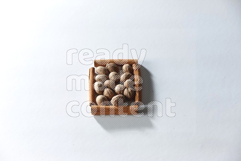 A single square of cinnamon sticks full of nutmeg on white flooring