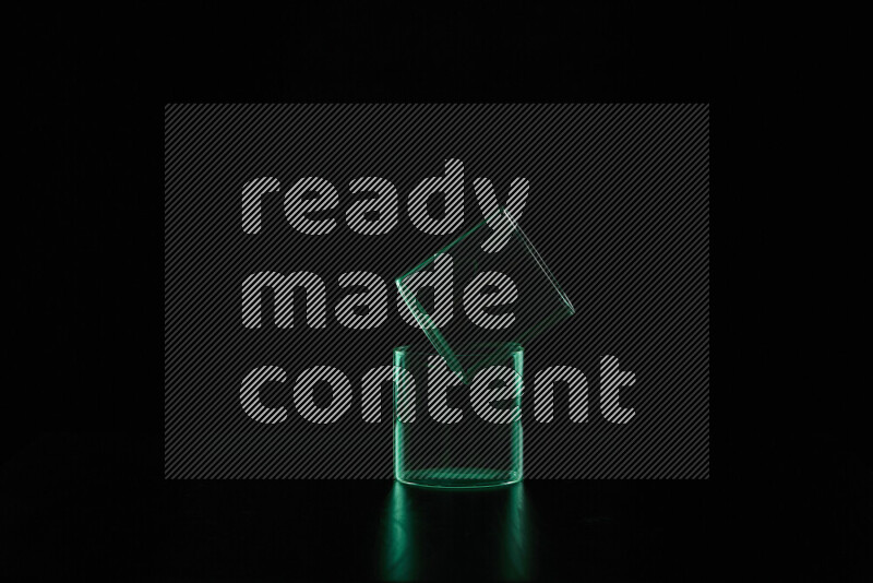 Glassware with rim light in green against black background