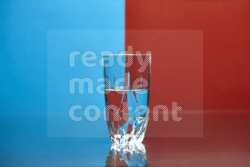 The image features a clear glassware filled with water, set against blue and red background