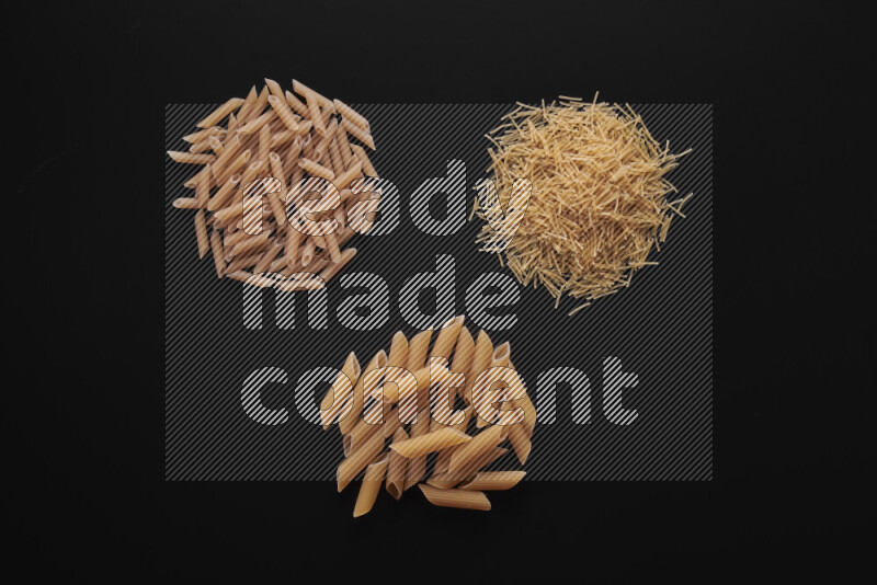 Different pasta types in bunches on black background