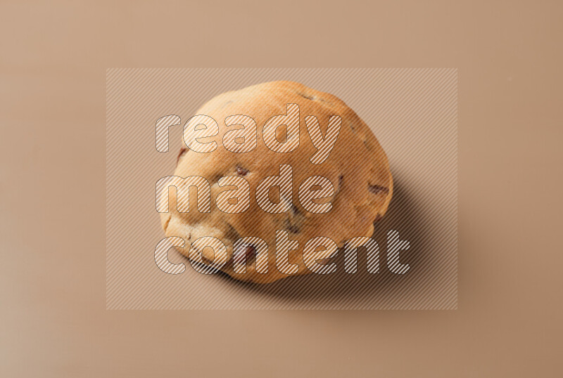 a whole chocolate chip cookie on a brown background