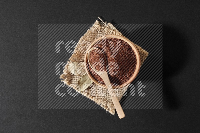 A wooden bowl full of garden cress with wooden spoon full of the seeds on it on burlap fabric on a black flooring in different angles