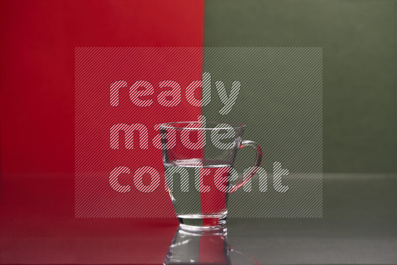 The image features a clear glassware filled with water, set against red and dark green background