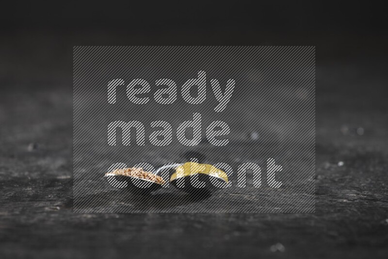 ملعقتان معدنيتان واحدة ممتلئة ببذور الخردل والأخري ممتلئة بمعجون الخردل علي خلفية سوداء