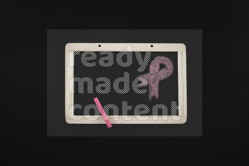A drawing of pink ribbon on blackboard on black background