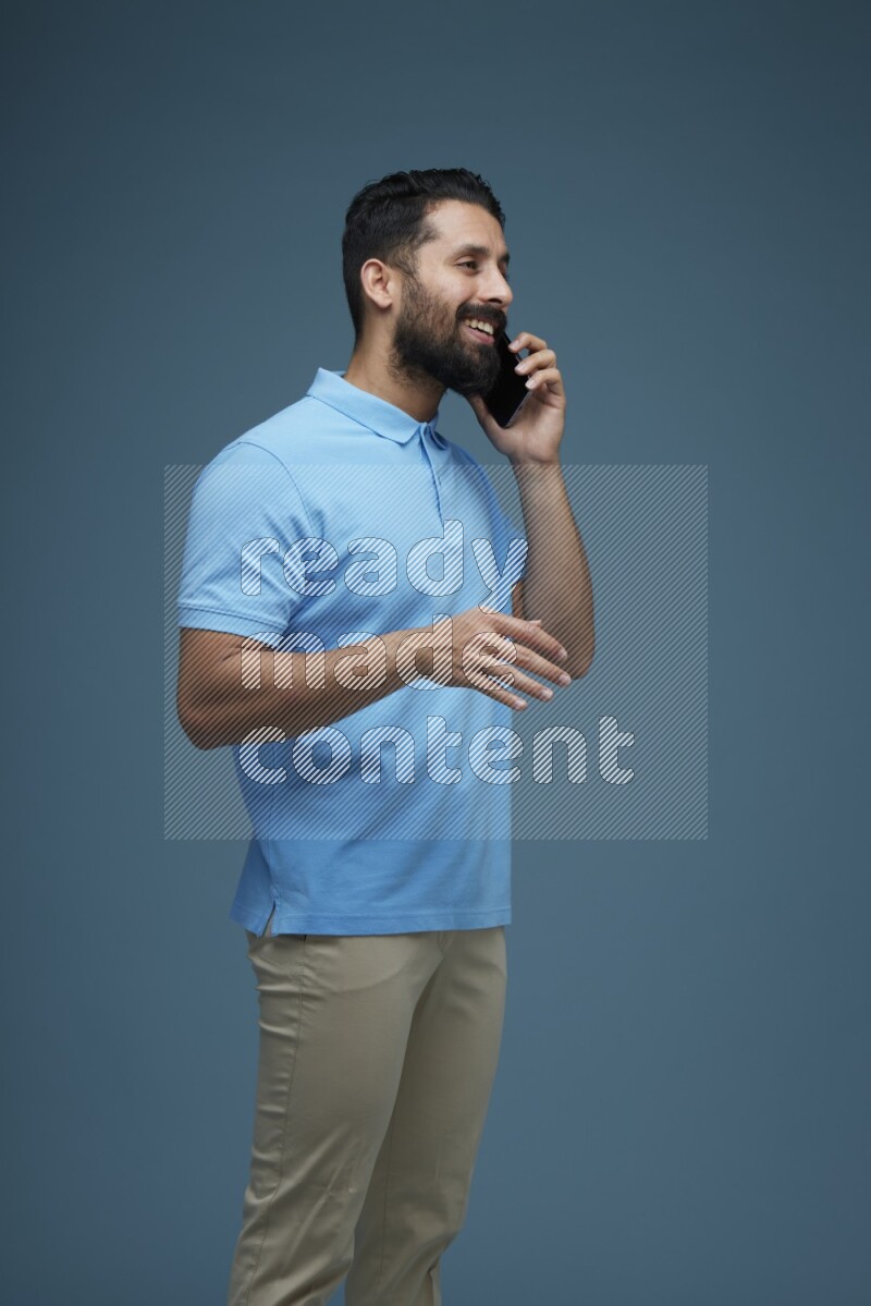 A man having a Call in a blue background wearing a Blue shirt