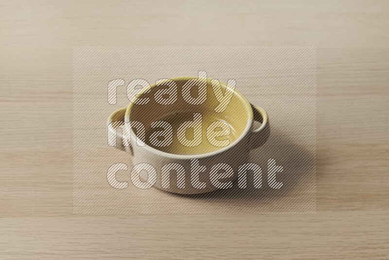 A multicolored pottery bowl on light wooden background