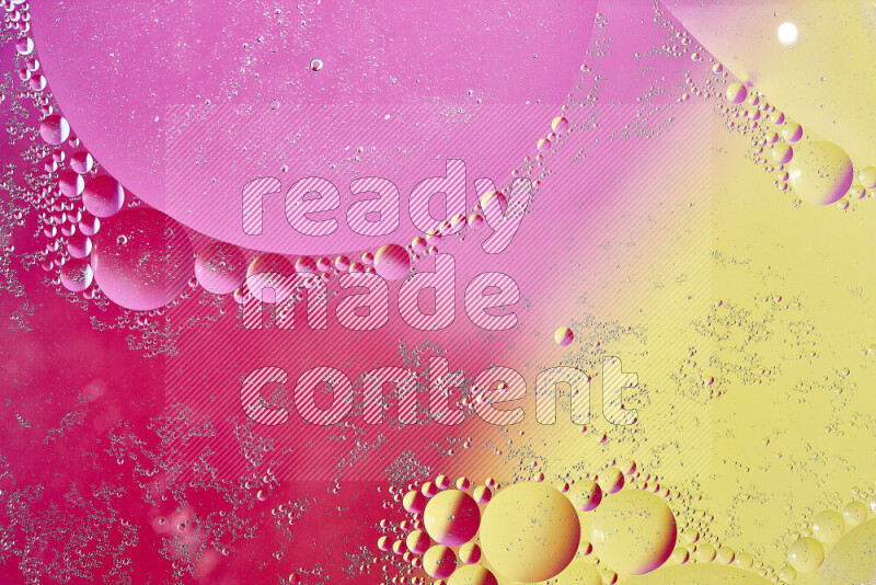 Close-ups of abstract oil bubbles on water surface in shades of yellow and pink