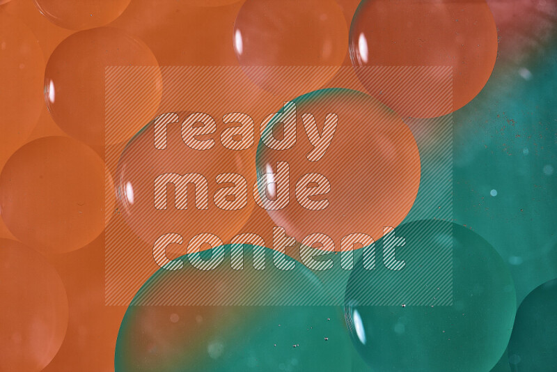 لقطات مقربة لفقاعات من الزيت على سطح الماء باللون الأخضر والبرتقالي