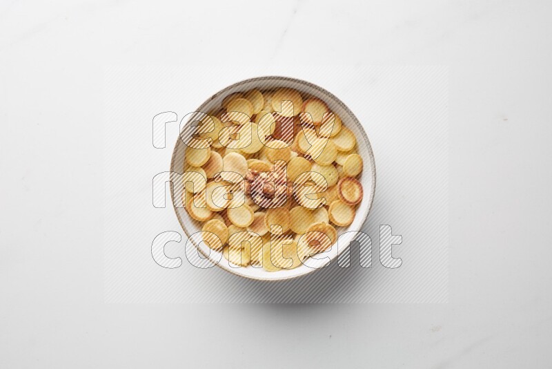 Top-view shot of walnut cereal pancakes in a round bowl on white background